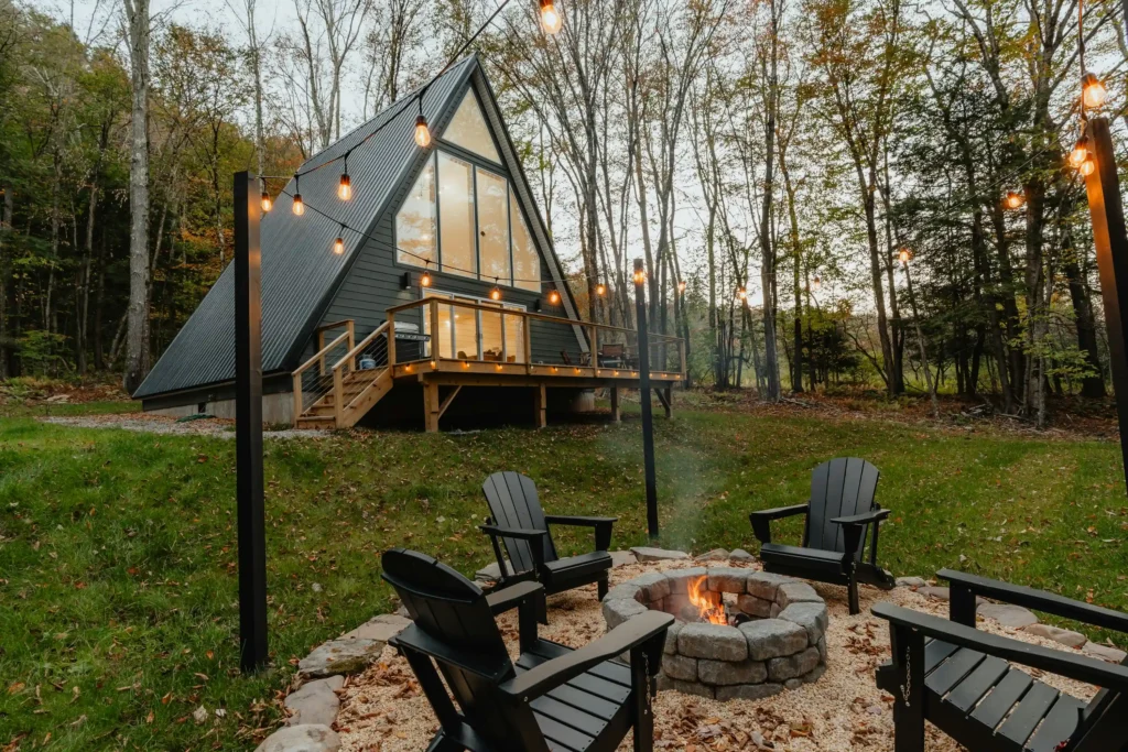 A-frame house with deck and fire pit in the forest